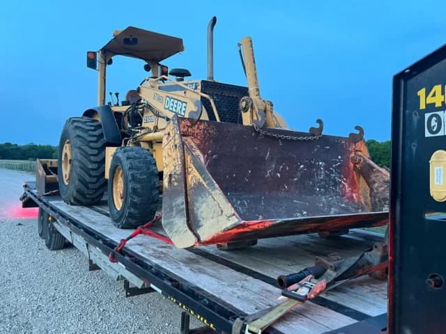Heavy loader secured on a flatbed trailer